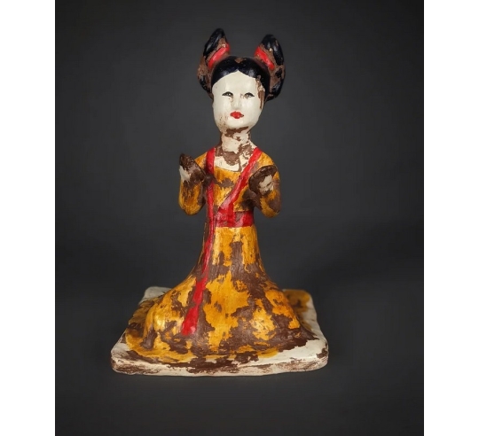 Estatuilla de una música sentada tocando...