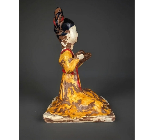 Statuette of a seated female musician playing...
