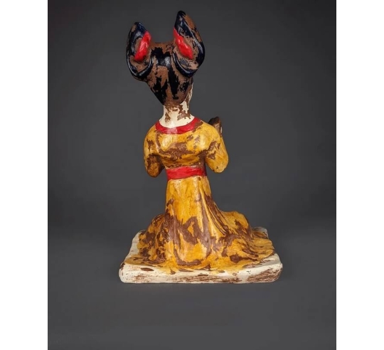 Statuette of a seated female musician playing...